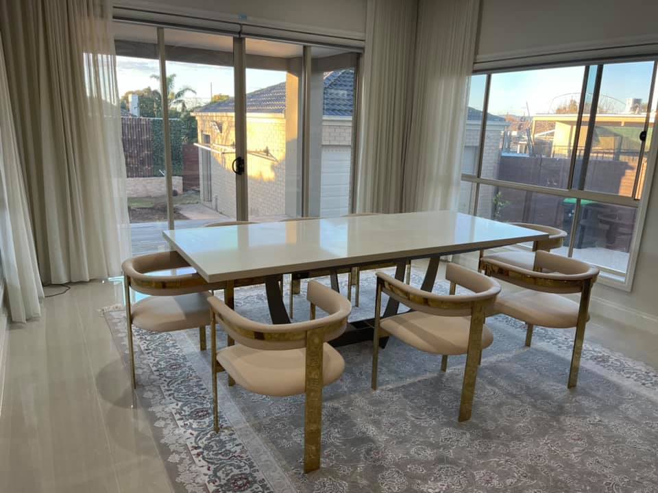 Wide view of a stone-topped dining table and chairs by sliding doors