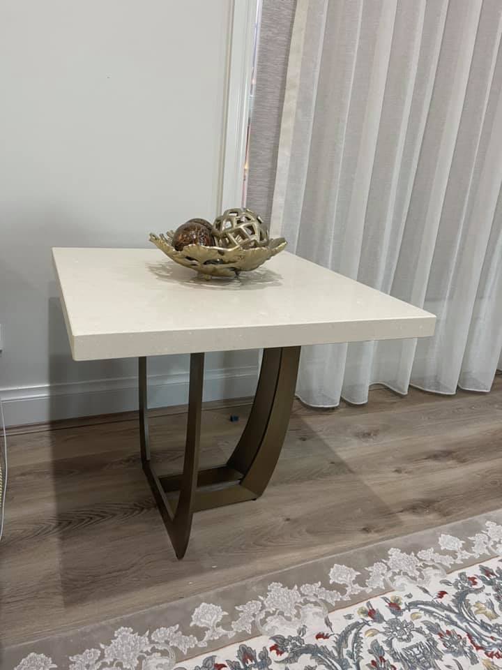 Small square side table with a pale stone top and metal base