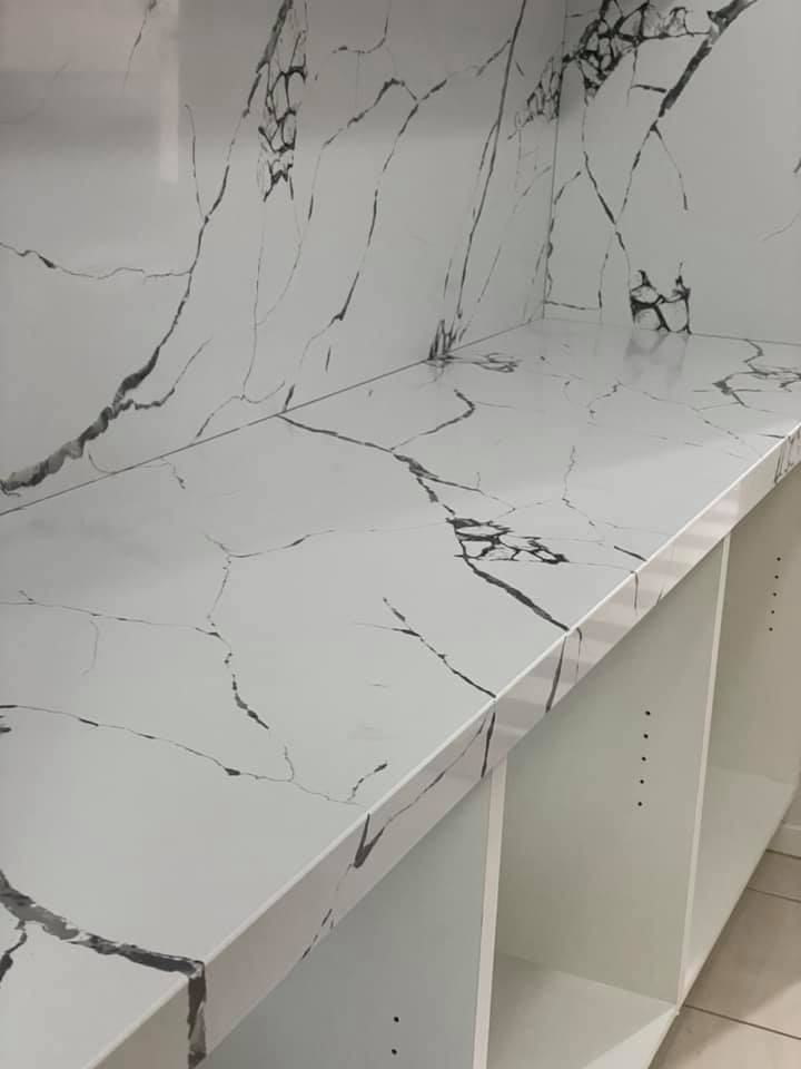 Close-up of a white benchtop and splashback with bold dark veining