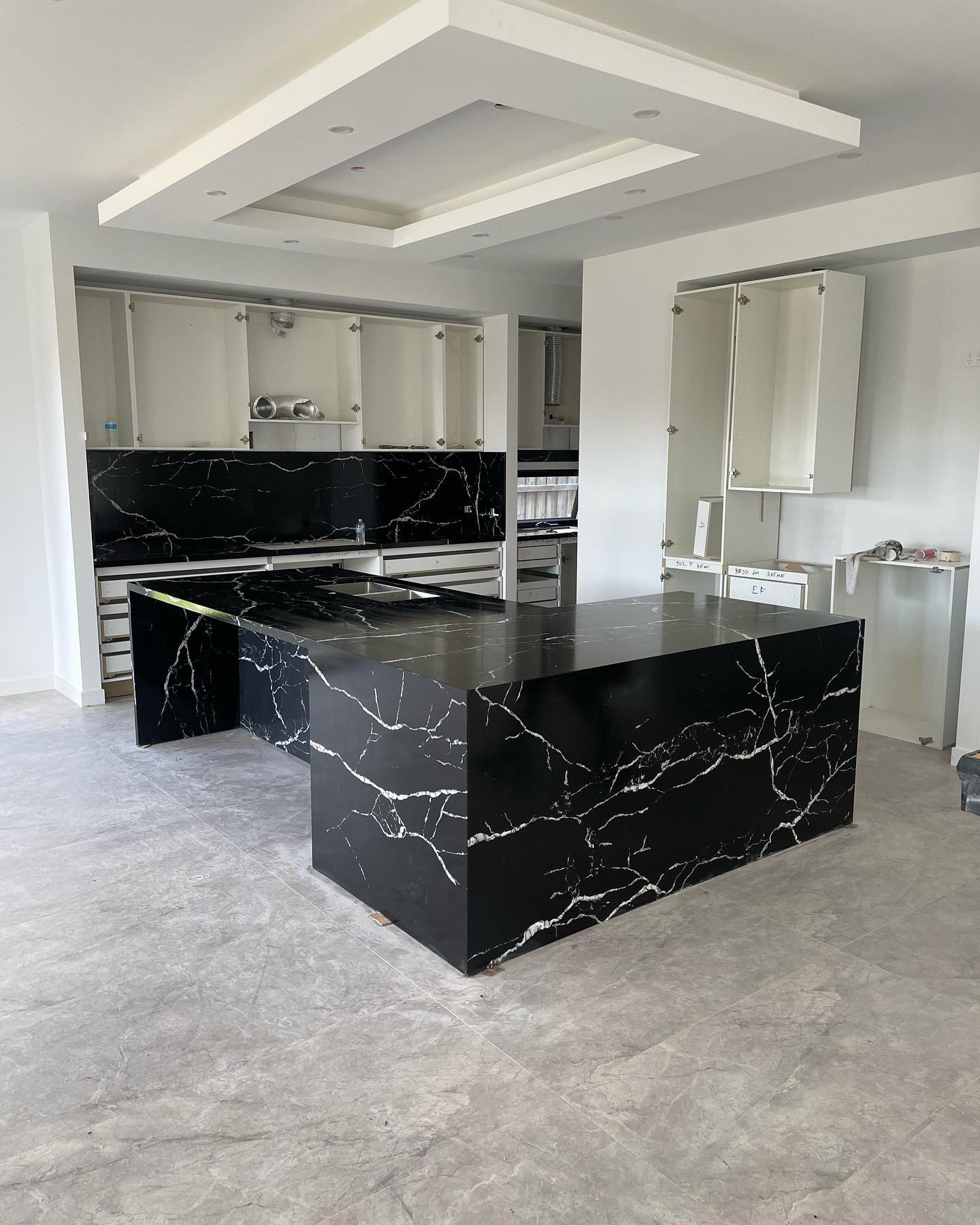 Black marble-look island and splashback with white veining