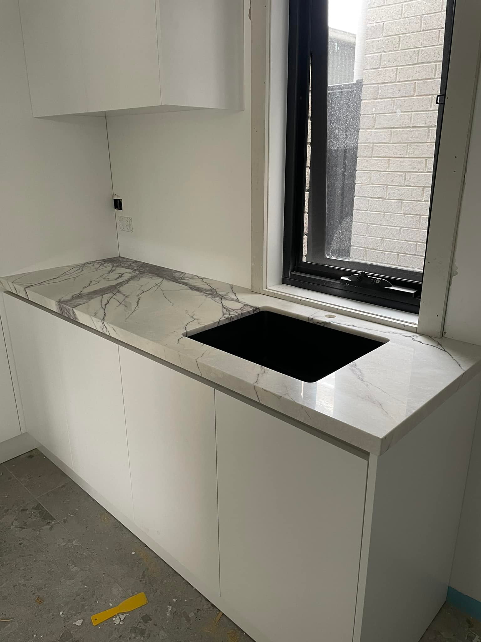 Purple-veined marble benchtop with a black undermount sink by a window