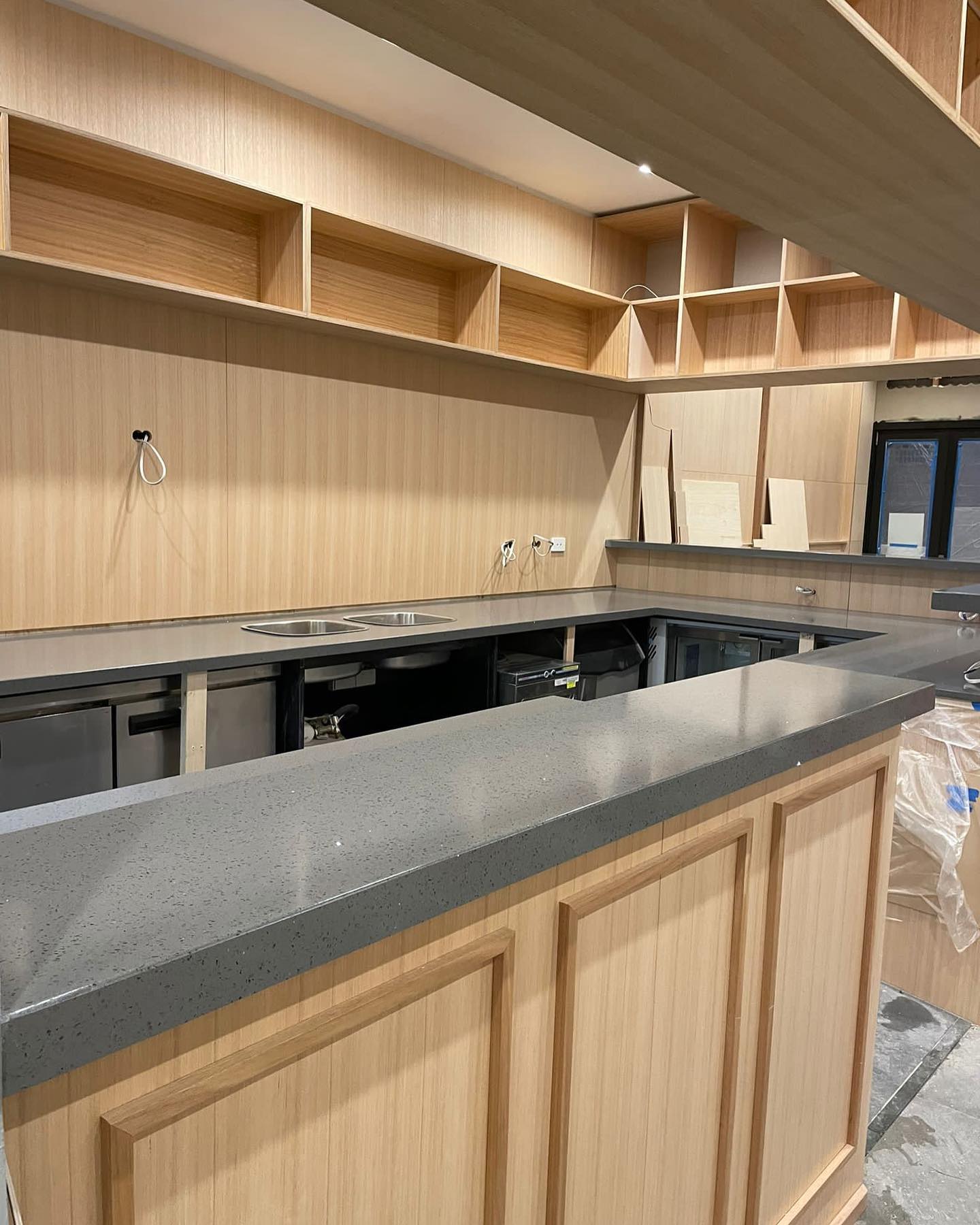 Close view of a grey stone counter with a timber panelled front