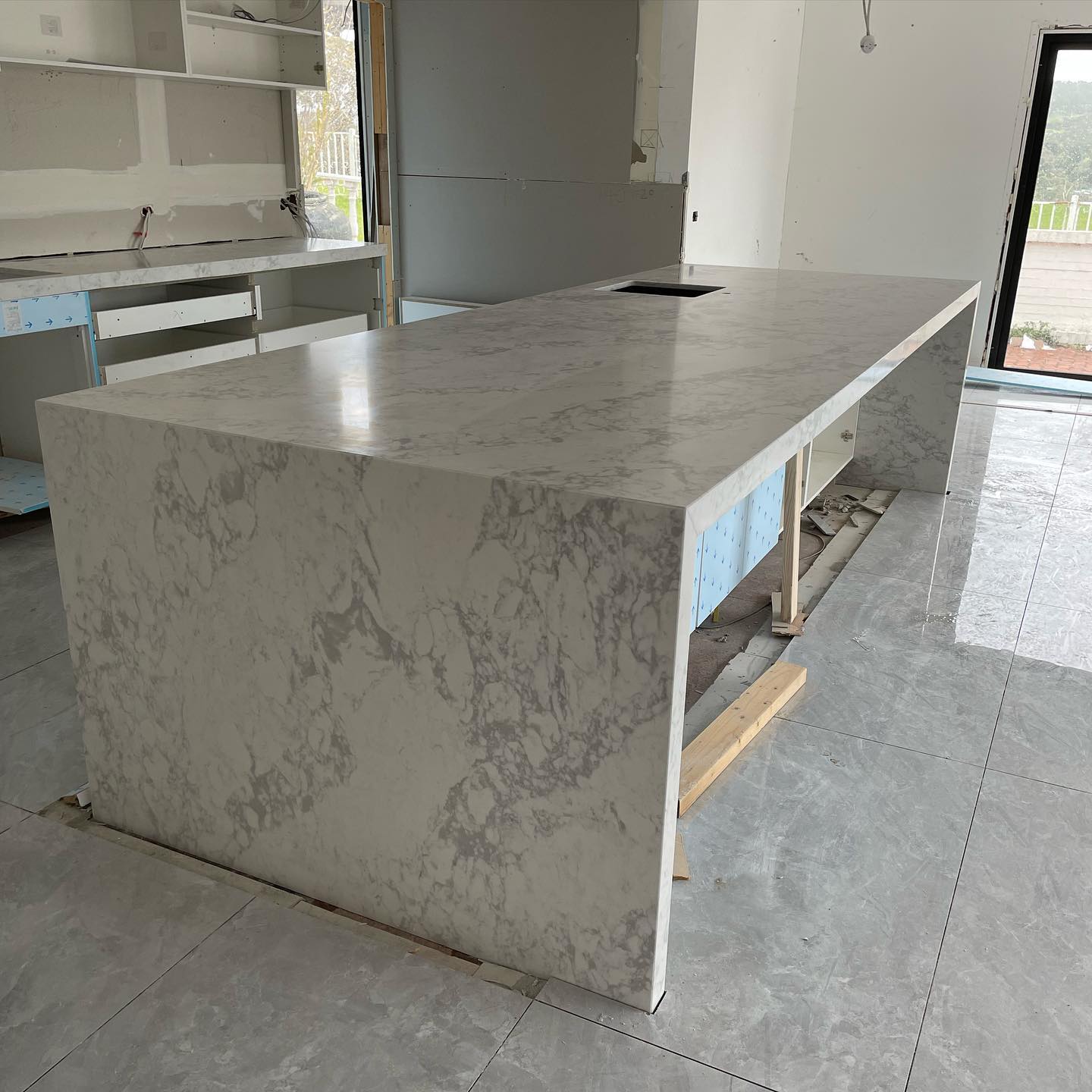 Close view of a white and grey marble-look waterfall island